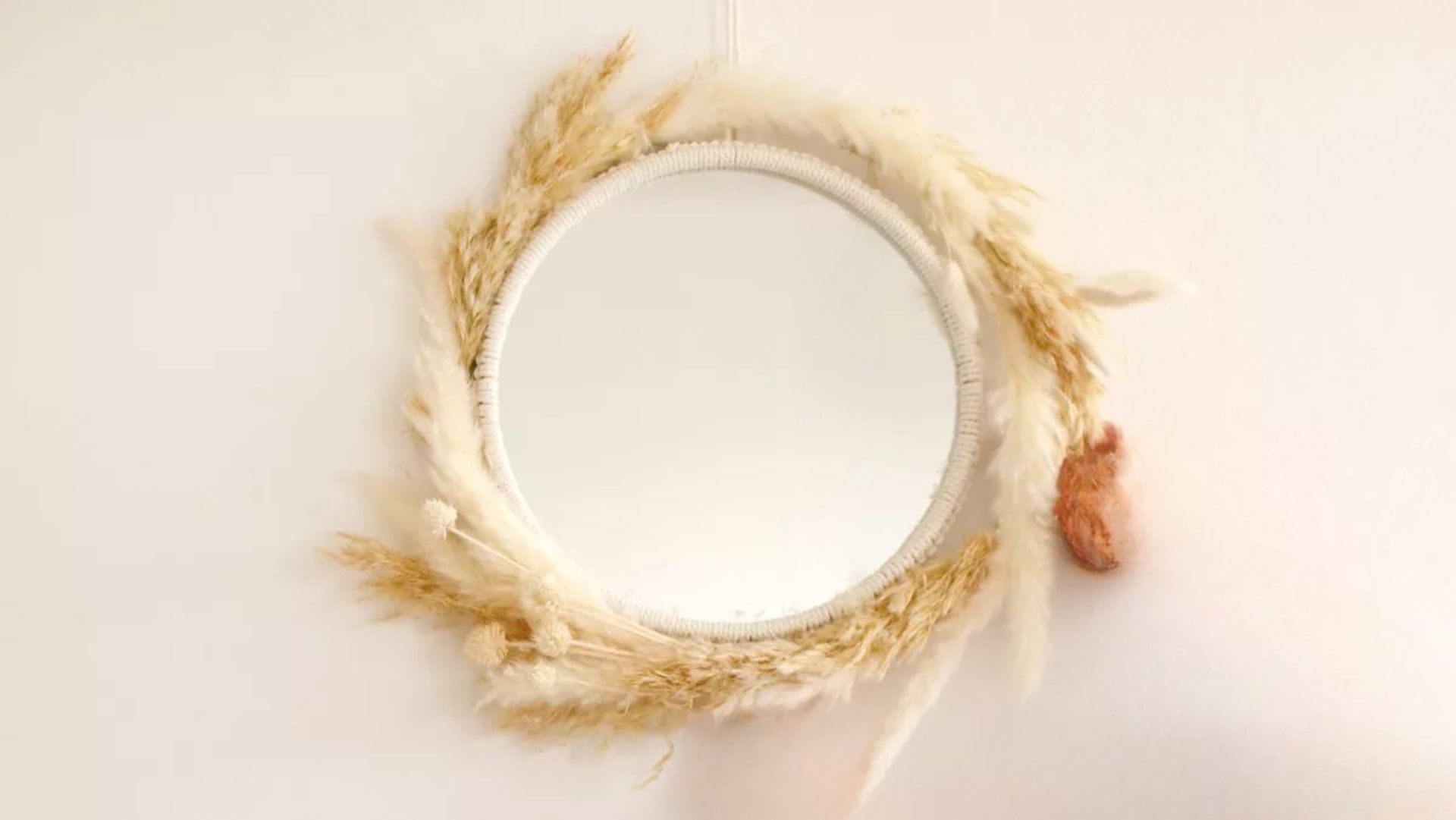 Miroir décoratif entouré de fibres naturelles et coquillages